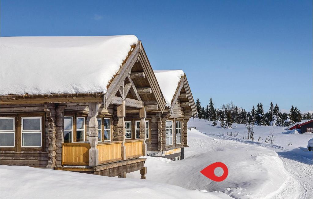 uma cabana de madeira na neve com um alvo vermelho em Sjusjen Setergrend 4724 C em Sjusjøen