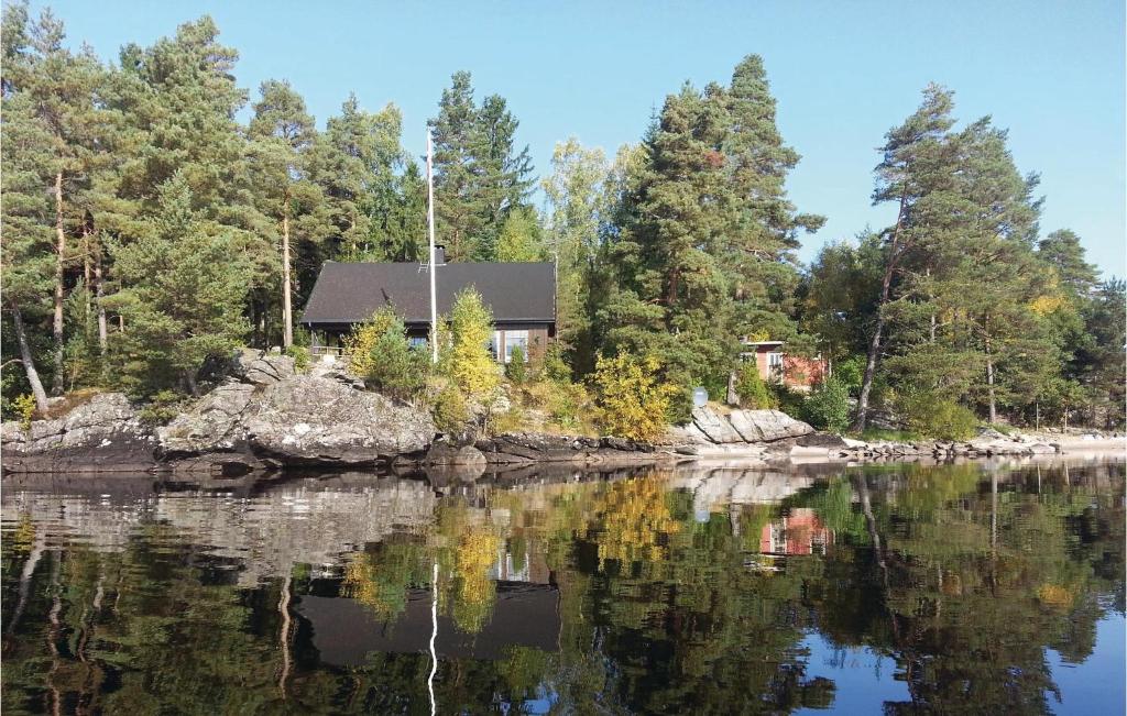 a house on the shore of a body of water at Trollstua in Asak