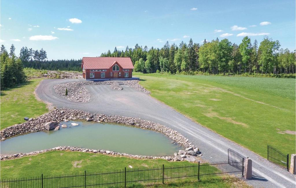 a house with a pond in the middle of a field at Beautiful Home In Aneby With Wifi in Aneby