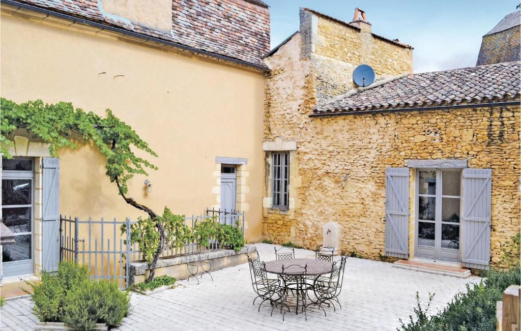 a patio with a table and chairs in front of a building at Stunning Home In Sainte Alvre With 6 Bedrooms, Sauna And Private Swimming Pool in Saint-Alvère