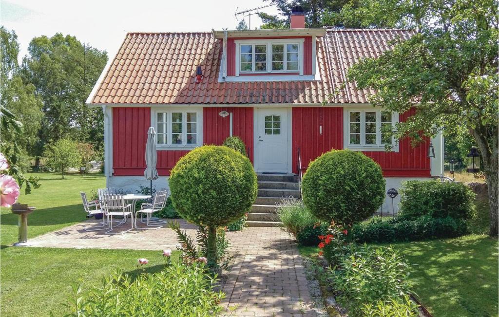 una casa roja con una mesa y sillas en un patio en Amazing Home In Slvesborg With Kitchen, en Hällevik