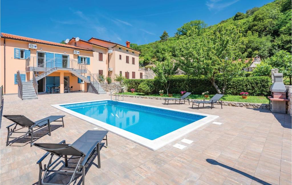 eine Villa mit einem Pool und einem Haus in der Unterkunft Amazing Home In Plomin With 3 Bedrooms, Wifi And Outdoor Swimming Pool in Plomin