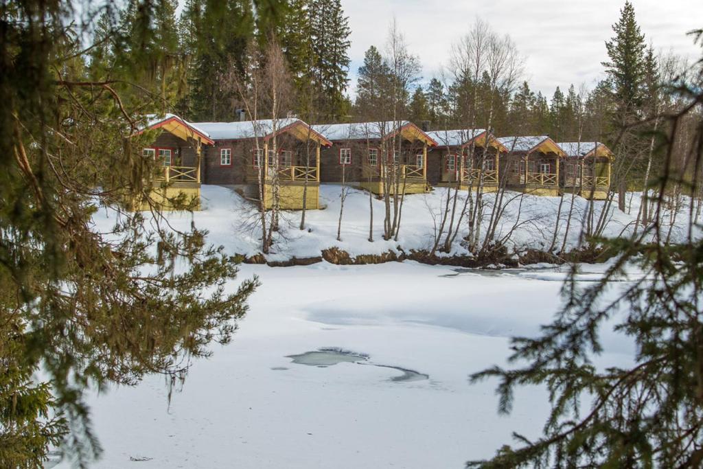 a group of wooden cabins in the snow at Vålkojan Naturby - Timber cottages in Vemdalen