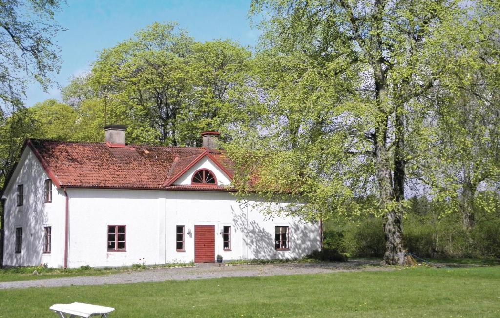 ein weißes Haus mit rotem Dach und einem Baum in der Unterkunft Holiday Home Flishult Gård Vetlanda in Vetlanda