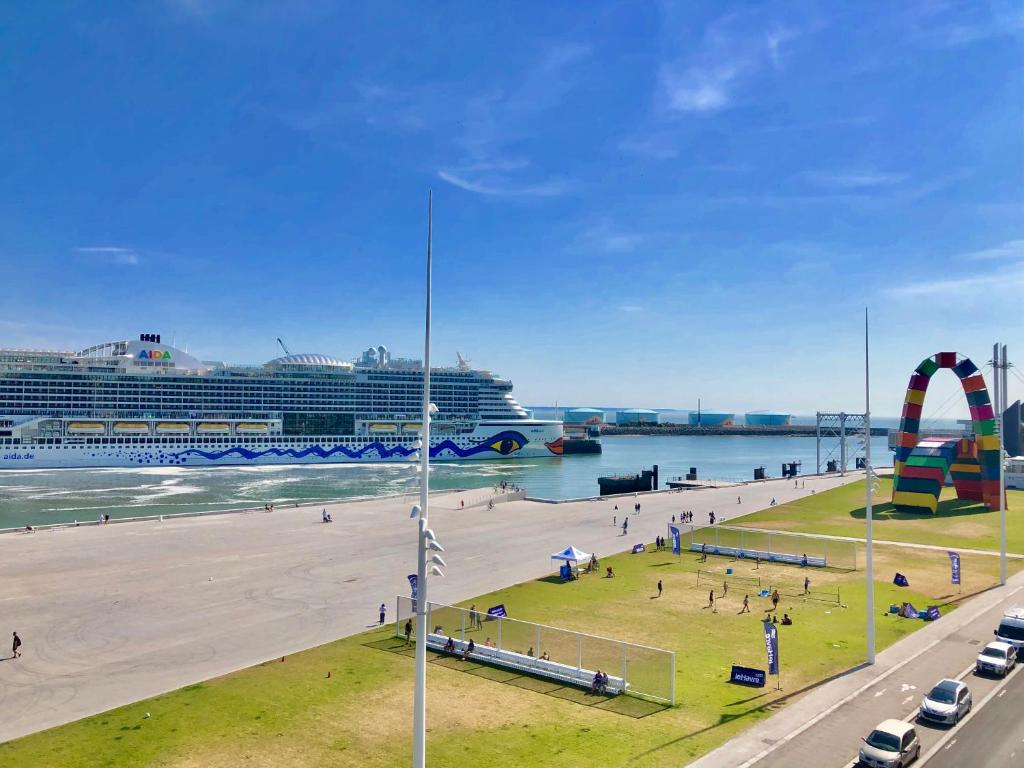 einen Strand mit einem Kreuzfahrtschiff im Wasser in der Unterkunft La Catène-Perret in Le Havre