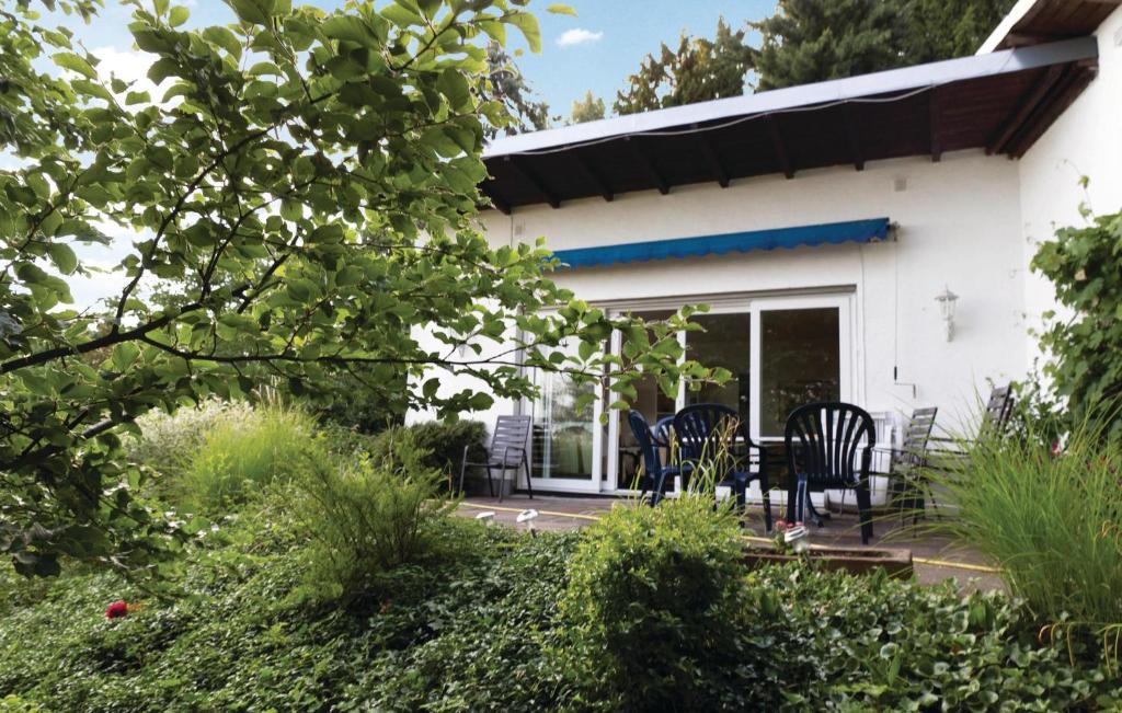 ein weißes Haus mit Stühlen und einem Tisch in der Unterkunft Awesome Home In Kelkheim-eppenhain With Wifi in Vockenhausen
