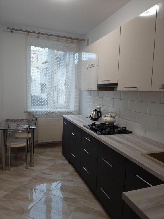 cocina con fogones y mesa. en Apartment in Serbska Lviv, en Leópolis