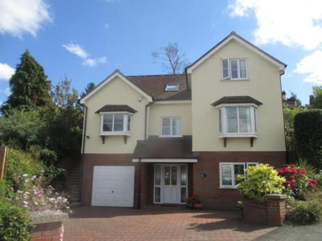 een huis met een garage en een oprit bij Birchwood House in Church Stretton