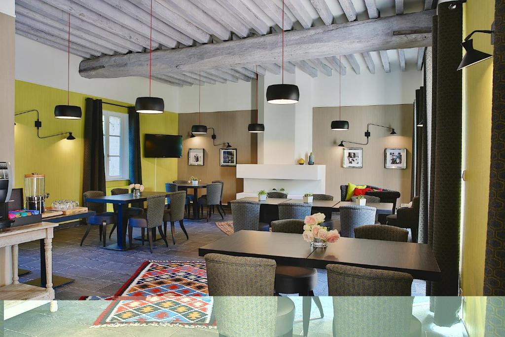 un restaurante con mesas y sillas en una habitación en Ferme du Roy, en Anserville