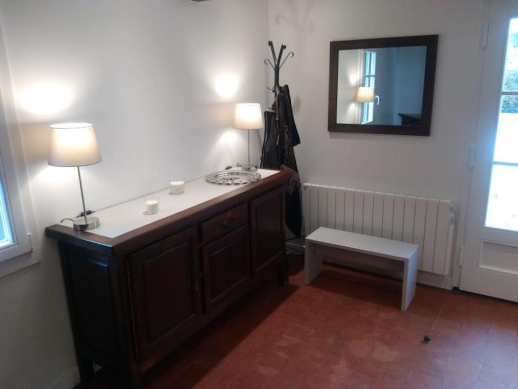 ein Badezimmer mit einem Waschtisch mit einem Spiegel und einem Stuhl in der Unterkunft La Parenthèse in Basseneville