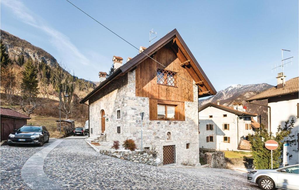 une maison en pierre avec un toit en bois dans une rue dans l'établissement Fornasiero 1, à Raveo