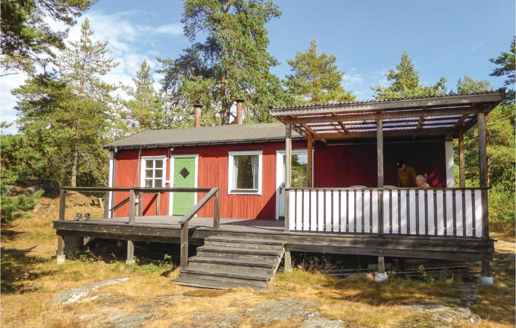 una casita roja pequeña con porche y escaleras en Beautiful Home In Trosa With House Sea View, en Trosa