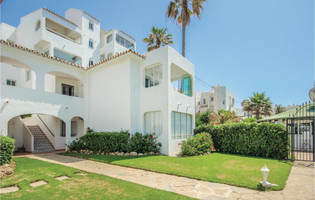 Sitio de CalahondaにあるStunning Apartment In Riviera Del Sol With 2 Bedrooms, Wifi And Outdoor Swimming Poolのヤシの木が背景に広がる白い家