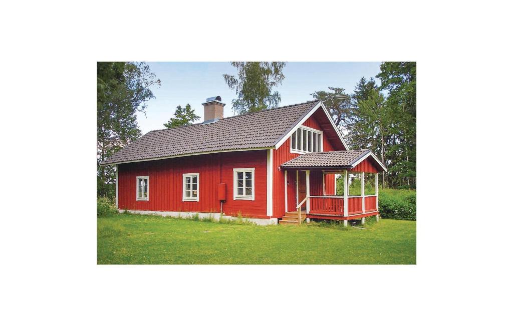 una casa roja con un cenador en la hierba en Cozy Home In Katrineholm With Lake View, en Katrineholm