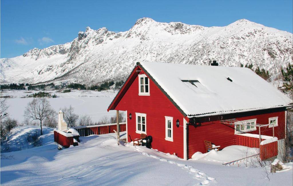 a red barn in front of a snow covered mountain at 4 Bedroom Lovely Home In Svolvr in Svolvær