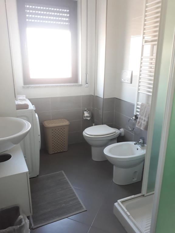 uma casa de banho branca com um WC e um lavatório em Belvedere em Policoro