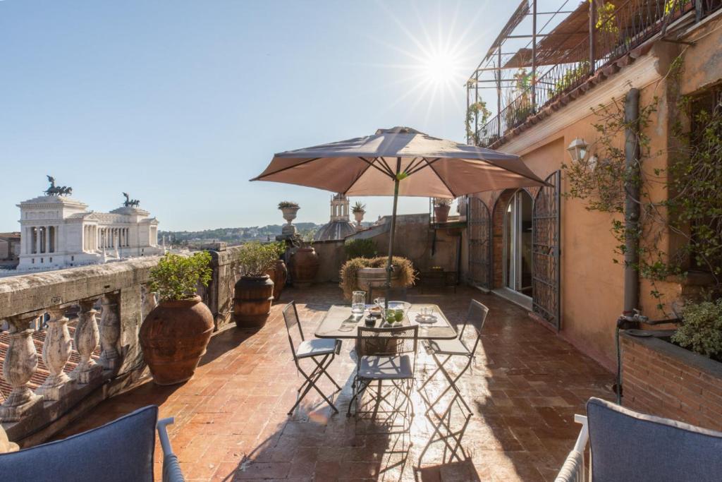 eine Terrasse mit einem Tisch und einem Sonnenschirm in der Unterkunft The Great View in Rom