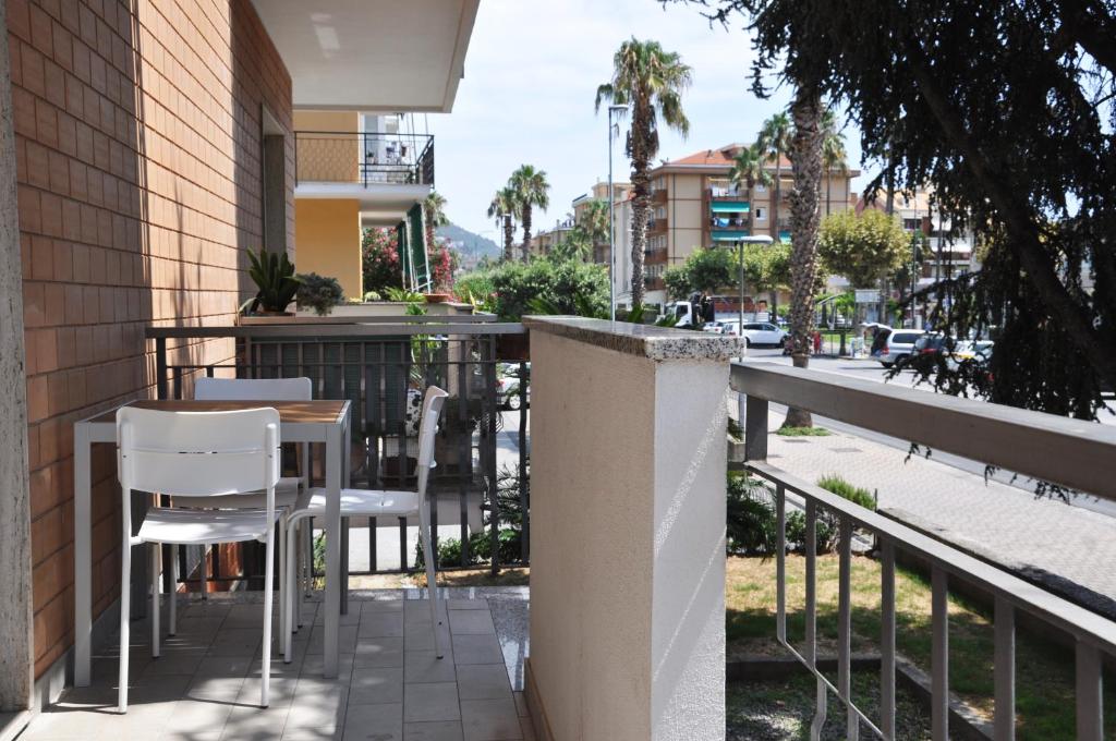 un tavolo e sedie su un balcone con una strada di VIALE REPUBBLICA 307 2 a Pietra Ligure