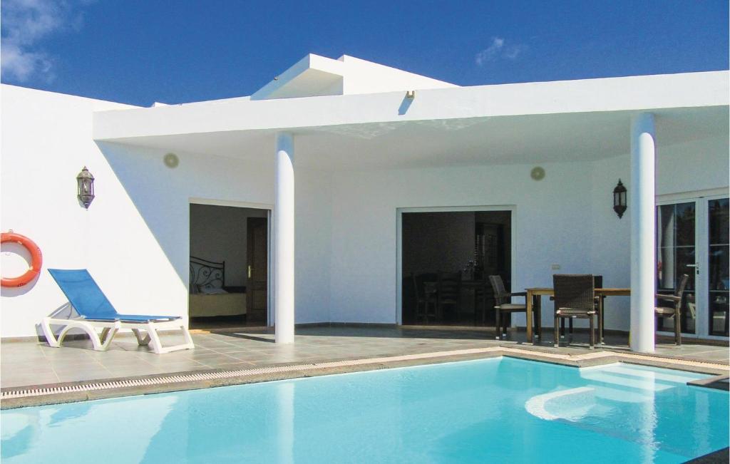 a villa with a swimming pool and a house at Villas Del Mar in Puerto Calero