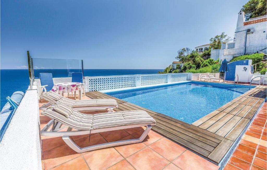 a swimming pool with lounge chairs and the ocean at Costa Nova in Jávea