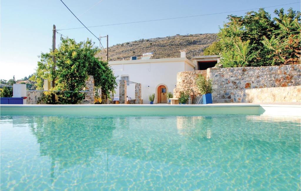 een zwembad met een huis op de achtergrond bij Gorgeous Home In Malaxa, Chania With Kitchen in Maláxa