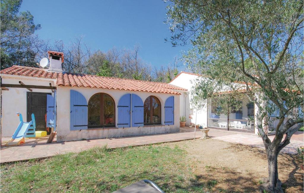 une petite maison avec une chaise bleue dans une cour dans l'établissement Lovely Home In Bagnols En Foret, à Bagnols-en-Forêt