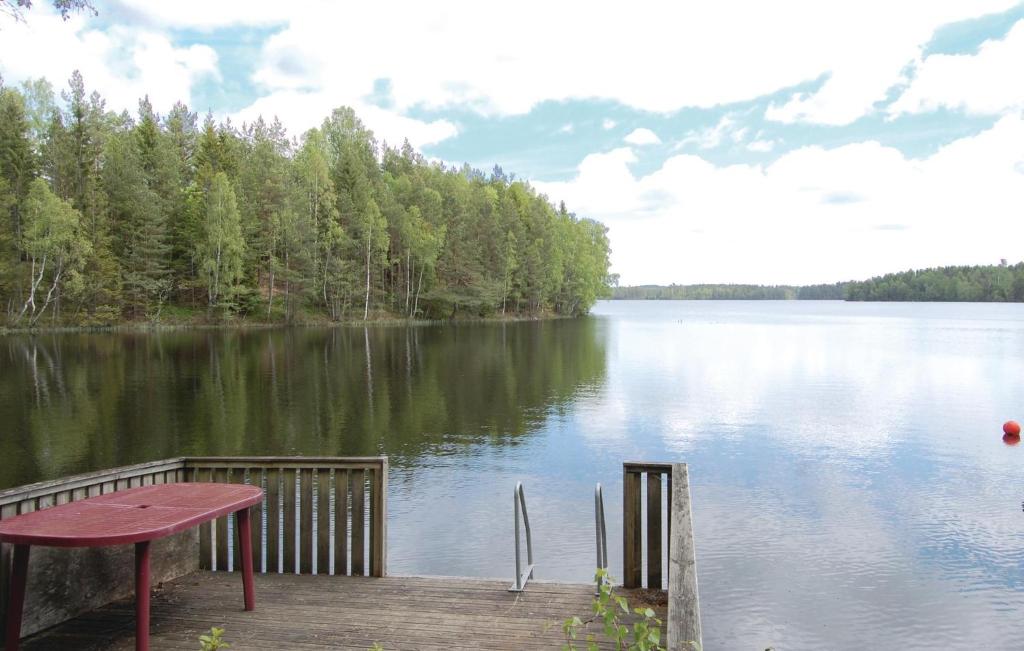 a wooden dock with a table and a view of a lake at 4 Bedroom Nice Home In Osby in Osby
