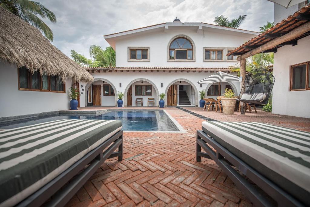 a villa with a swimming pool and a house at Villa San Juan Bed&Breakfast in Nuevo Vallarta
