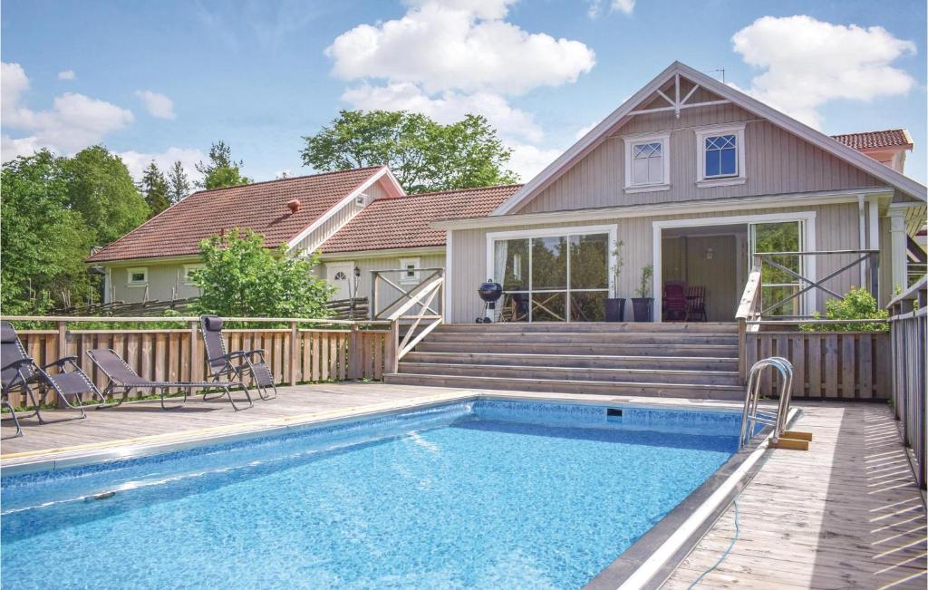 una casa con piscina frente a una casa en Lovely Home In Trans With Kitchen en Bjärsjö