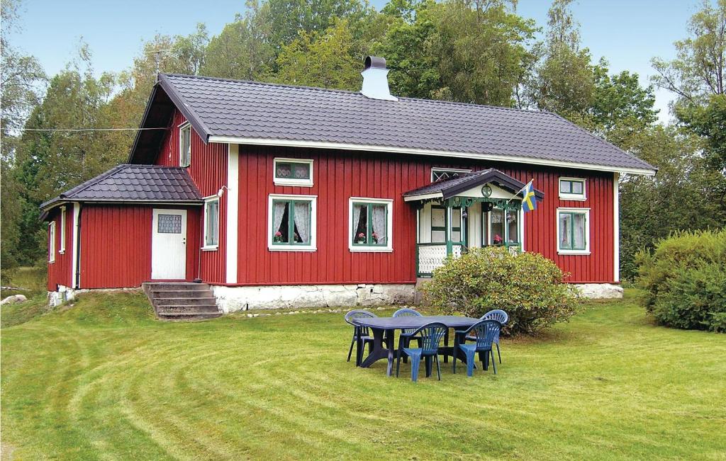 uma casa vermelha com uma mesa de piquenique em frente em Lovely Home In Ambjrnarp With Wifi em Emtashult
