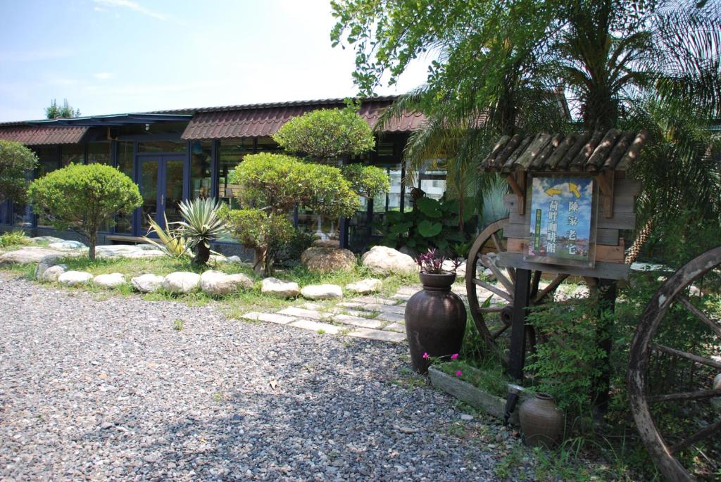 a house with a vase sitting in front of a yard at Lotus Hostel Beicheng Zhuang in Luodong