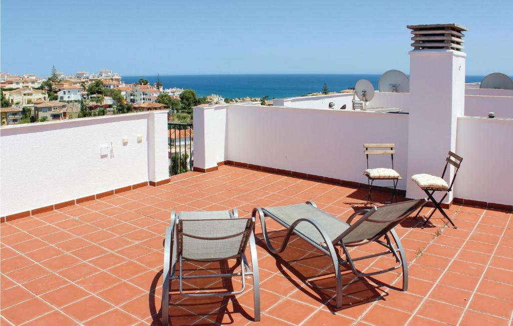 ラ・カラ・デ・ミハスにあるCozy Apartment In Miraflores With Wifiの屋上のパティオ(椅子、テーブル付)