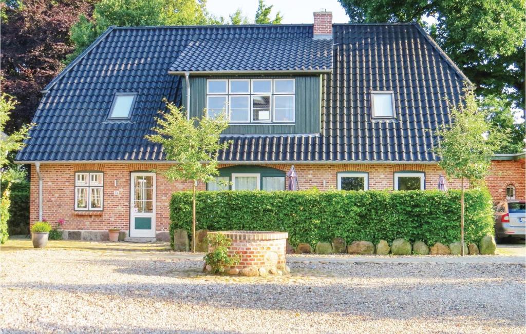 a red brick house with a blue roof at Cozy Home In Gammelby With Sauna in Gammelby