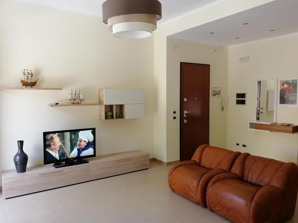 un soggiorno con divano e TV a schermo piatto di Casa Lidia a Castellammare del Golfo