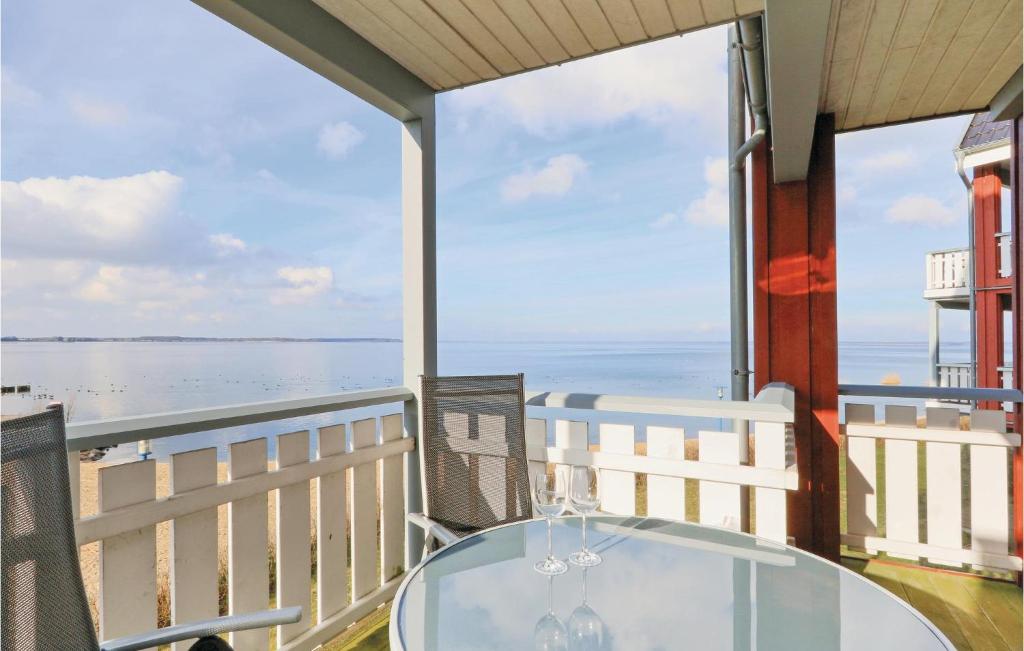 レヒリンにあるNice Apartment In Rechlin With 1 Bedrooms And Wifiの海の景色を望むバルコニー(ガラス張りのテーブル付)