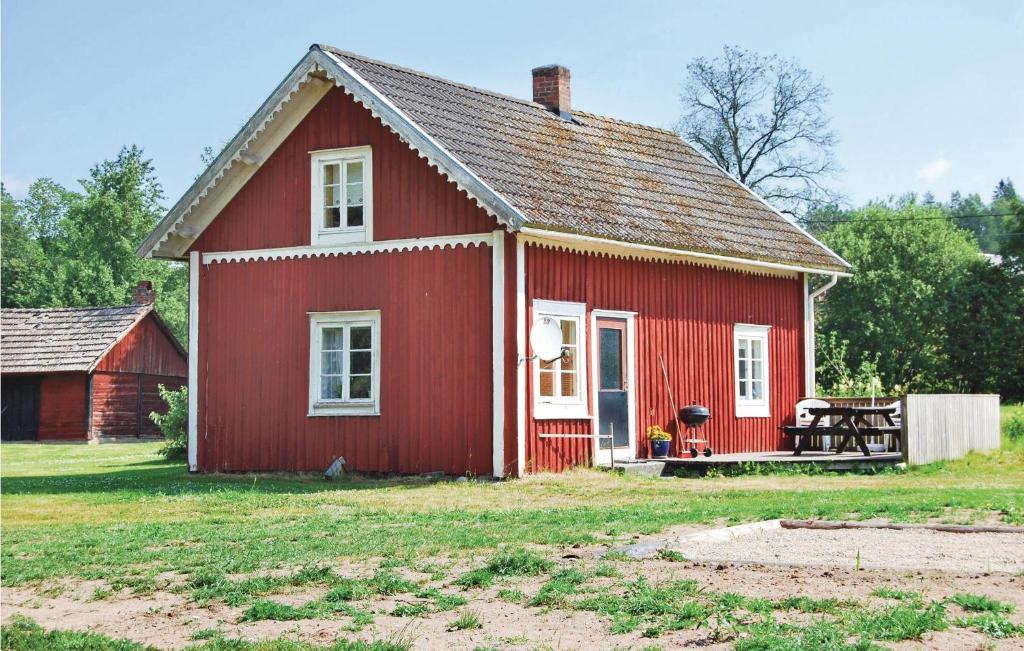 a red house with a bench in front of it at 2 Bedroom Beautiful Home In Linneryd in Linneryd