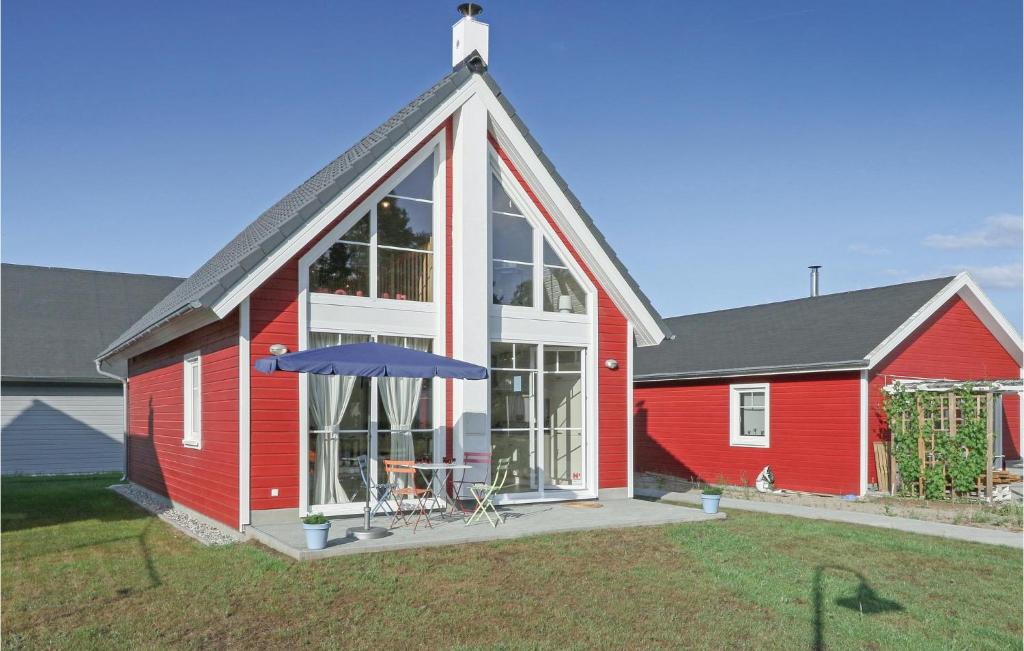 a red house with a large window and an umbrella at Beautiful Home In Zerpenschleuse in Zerpenschleuse