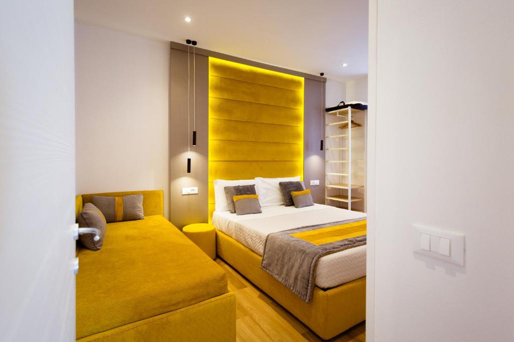 拉斯佩齊亞的住宿－Elegant Apartments 5 terre la spezia，一间卧室配有一张床和一个黄色床头板