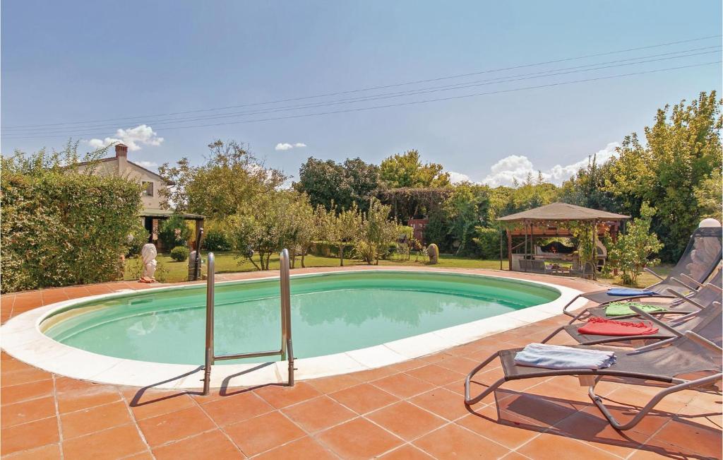 San Giovanni Alla Vena的住宿－Fienile，一个带两把椅子的游泳池和一个凉亭