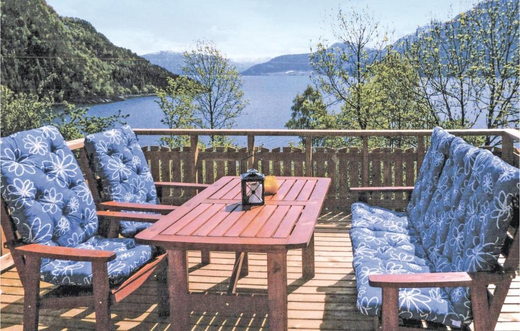 een houten tafel en twee stoelen op een terras bij Cozy Home In Nordfjordeid With Kitchen in Nordfjordeid