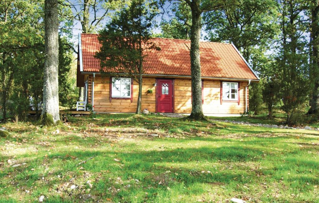a small house with a red door in a field at Beautiful Home In Svsj With 3 Bedrooms And Wifi in Gistingstorp