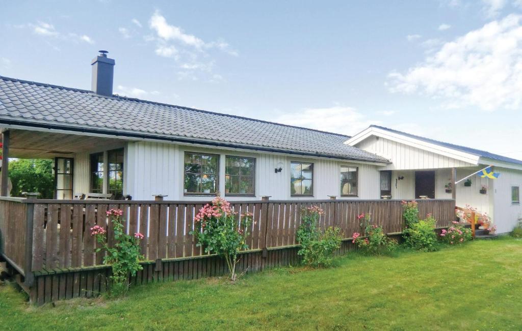 een huis met een houten hek en bloemen bij Beautiful Home In Borgholm With Kitchen in Föra