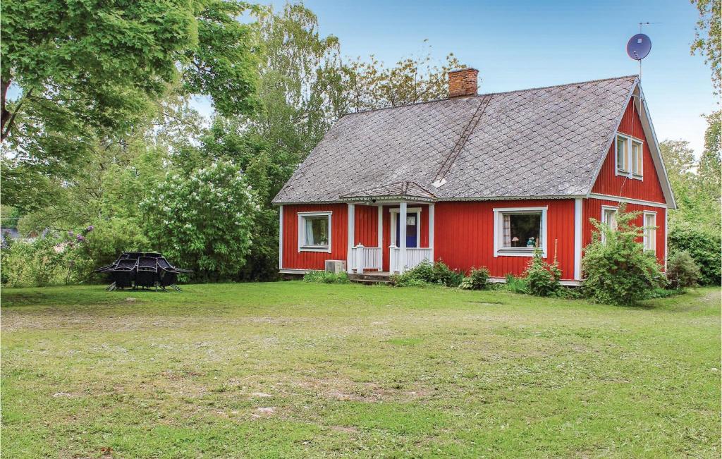 a red house with a large yard in front of it at 4 Bedroom Nice Home In Slvesborg in Sandbäck