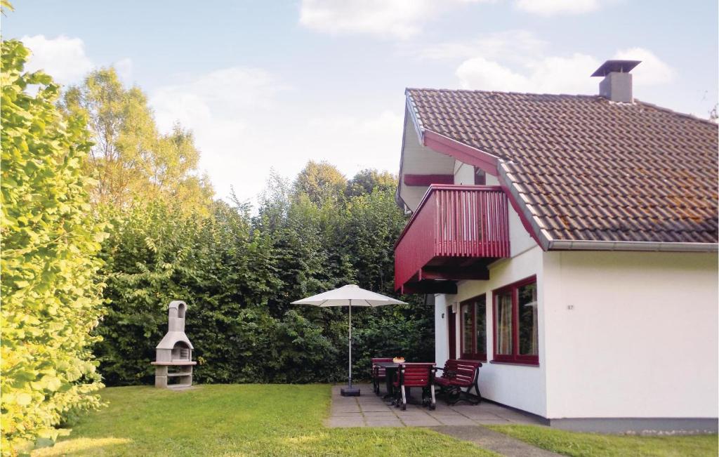 KemmerodeにあるFerienhaus 87 In Kirchheimのパティオ(椅子、パラソル付)が備わる家