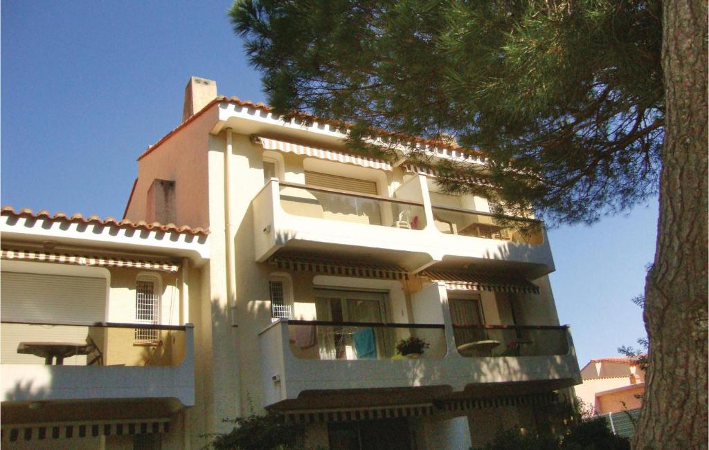 een wit gebouw met een boom ervoor bij Amazing Apartment In Argeles Sur Mer With Kitchen in Plage dʼArgelès
