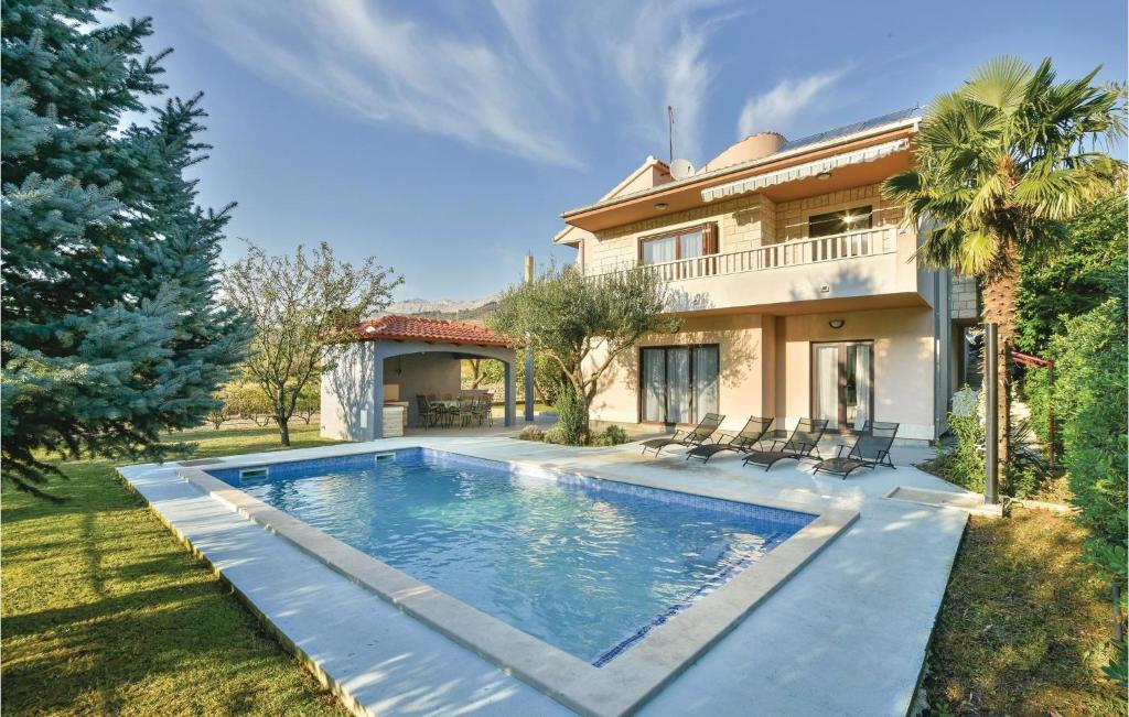 a swimming pool in front of a house at Awesome Home In Srinjine With Wifi, Private Swimming Pool And Outdoor Swimming Pool in Srinjine