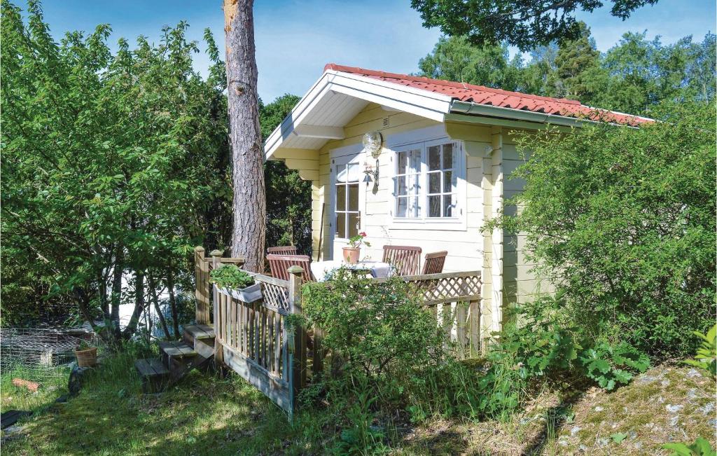 a small white house with a porch and a tree at Awesome Home In Sr With Wifi in Särö