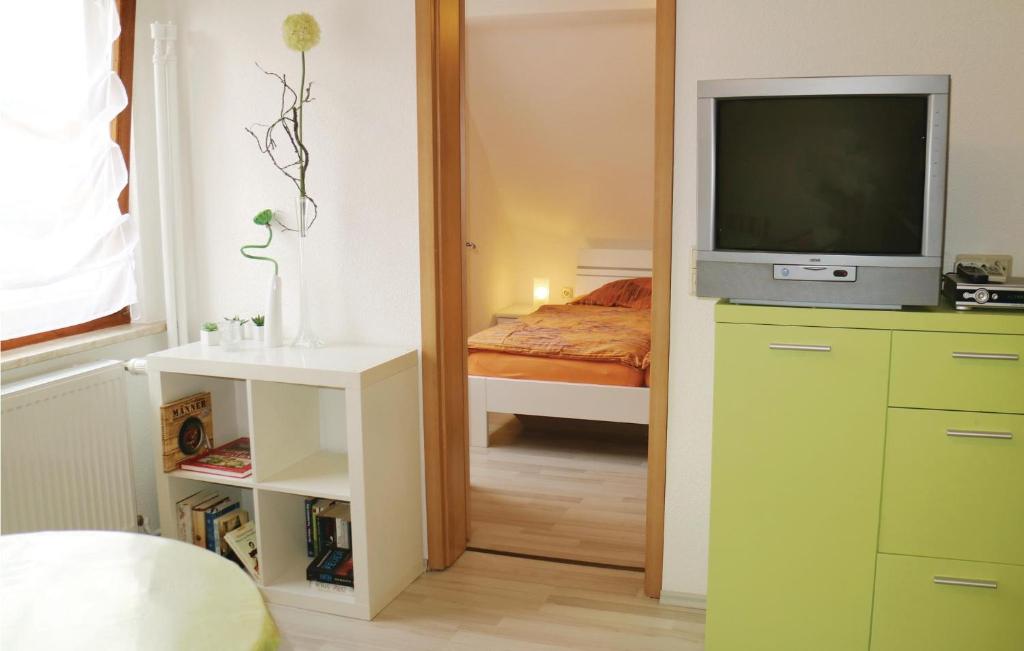 una camera con televisore e una camera con letto di Nice Apartment In Nahetal-waldau With Wifi a Hinternah