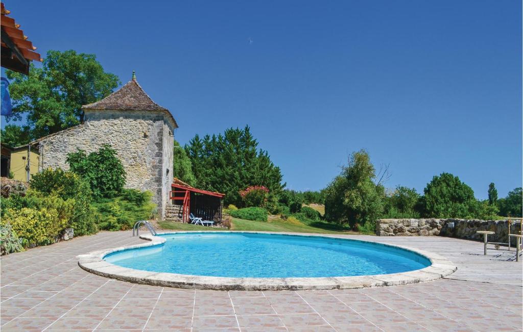 エイメにあるAwesome Home In Eymet With 1 Bedrooms And Outdoor Swimming Poolの石造りの建物のある庭のスイミングプール