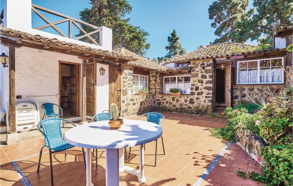 a patio with a table and chairs in front of a house at Casa Los Pinos in Icod de los Vinos